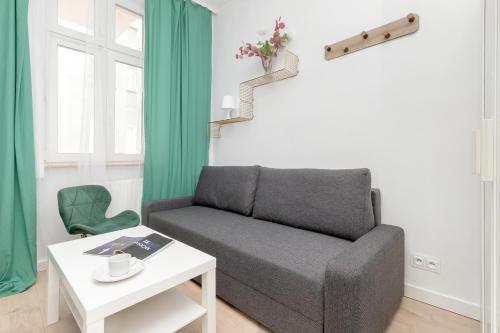 uma sala de estar com um sofá e uma mesa em Cosy Studios near the Old Town in Gdańsk by Renters em Gdansk
