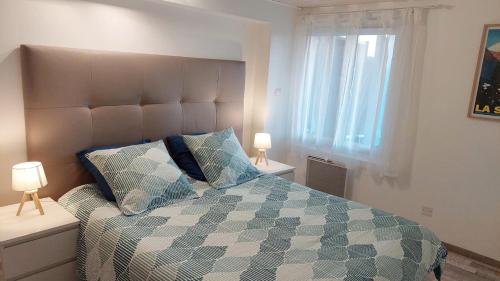 1 dormitorio con 1 cama, 2 lámparas y ventana en La marmotte Appartement privatif 2 chambres proche du lac d'aiguebelette en Saint-Béron