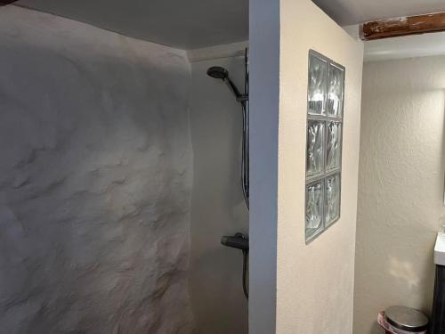 um chuveiro numa casa de banho com uma parede em Seaside Cottage em Oyndarfjørður