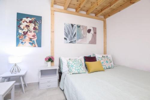 a white bedroom with a bed and a table at Casa Niovi, Acharavi in Acharavi