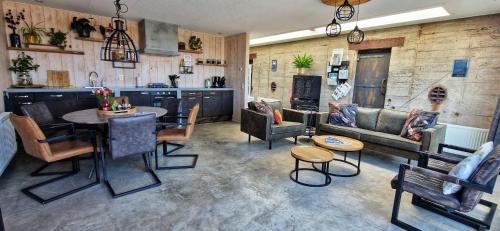 a living room filled with furniture and a table at Vakantiehuis De Bunker in Julianadorp