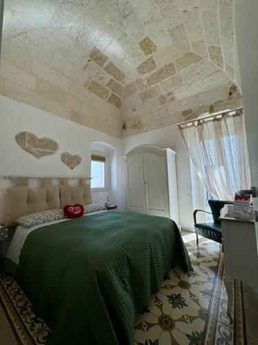 a bedroom with a bed with a green bedspread at Petali Rosa - Dimora Verde in Polignano a Mare