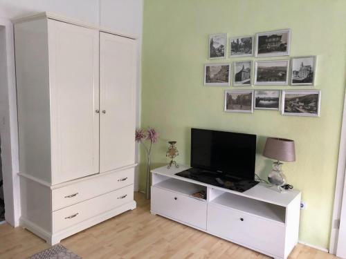 a living room with a white cabinet and a tv at Stadtmitte-Iserlohn in Iserlohn