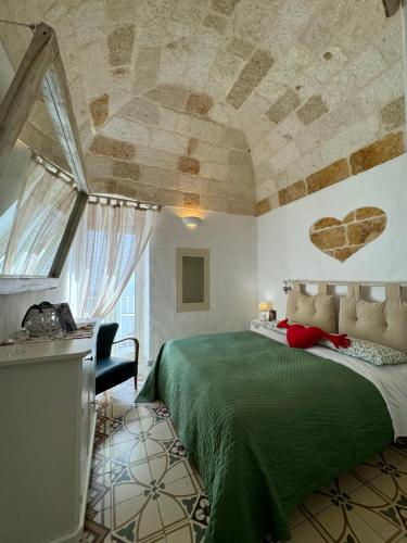 ein Schlafzimmer mit einem grünen Bett und einer Steindecke in der Unterkunft Petali Rosa - Dimora Verde in Polignano a Mare