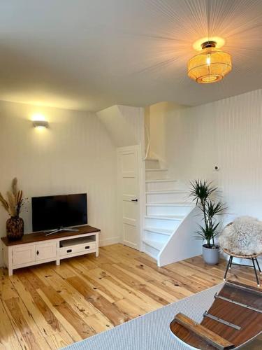 a living room with a television and a staircase at Appartement Sneek in Sneek