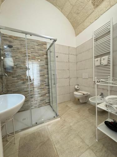 ein Bad mit einer Dusche, einem Waschbecken und einem WC in der Unterkunft Petali Rosa - Dimora Verde in Polignano a Mare