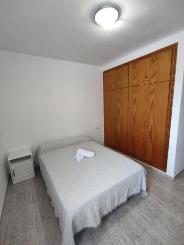 Casa Laurel في Camarles: غرفة نوم بسرير وخزانة خشبية