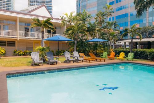 a pool at a hotel with chairs and umbrellas at Waikiki Heritage Hotel in Honolulu