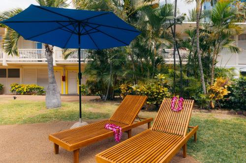 two wooden benches with a blue umbrella at Waikiki Heritage Hotel in Honolulu