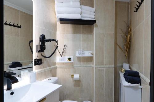 a bathroom with a sink and a toilet and towels at Apartamento Exclusivo Centrico con parking in Ribadeo
