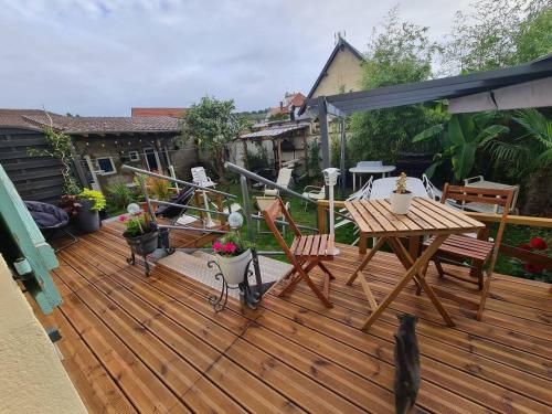 a wooden deck with a table and chairs on it at Maison spacieuse avec cheminée à Dives-sur-Mer in Dives-sur-Mer