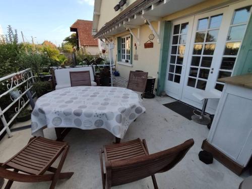a patio with a table and chairs on a porch at Maison spacieuse avec cheminée à Dives-sur-Mer in Dives-sur-Mer