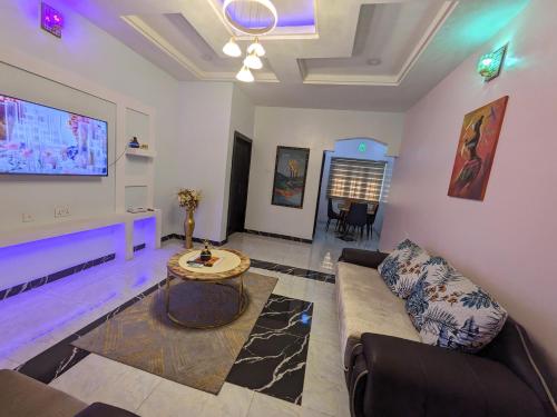 ein Wohnzimmer mit einem Sofa und einem TV in der Unterkunft Racvity Homes Limited in Akwa