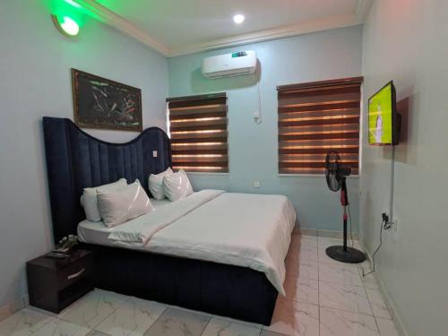 ein Schlafzimmer mit einem großen Bett in einem Zimmer in der Unterkunft Racvity Homes Limited in Akwa