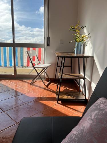 a living room with a table and a large window at 10 to Ocean in Figueira da Foz