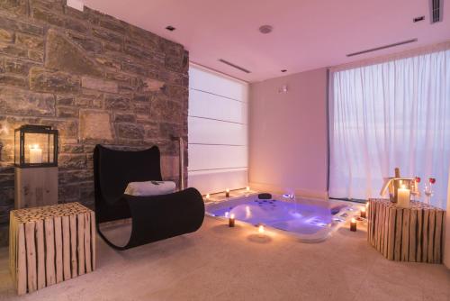 uma sala de estar com uma parede de pedra e uma banheira de hidromassagem em Residence Monte near Umag for 10 people with heated infinity pool & spa 