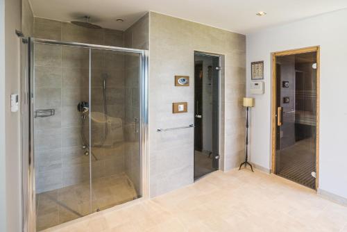 um chuveiro com uma porta de vidro na casa de banho em Residence Monte near Umag for 10 people with heated infinity pool & spa 