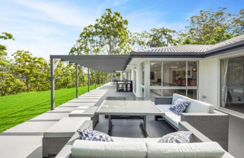 an outdoor patio with couches and a table at Hinterland Heights in Canungra