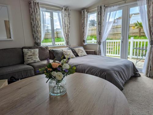 una sala de estar con un jarrón de flores sobre una mesa en 11 Meadow View en Newquay