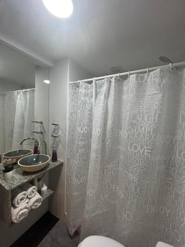 y baño con cortina de ducha y lavamanos. en Apartments Belgrano en Buenos Aires