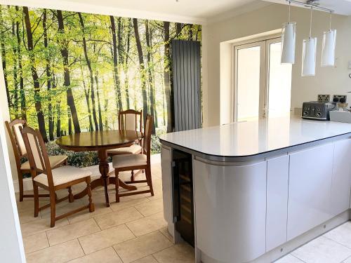 a kitchen with a table and a dining room at Spacious Five-Bedroom House Close to York Centre - Orchid House in York