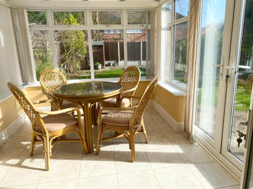a dining room with a table and chairs and windows at Spacious Five-Bedroom House Close to York Centre - Orchid House in York