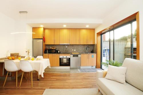 a kitchen and living room with a table and chairs at marAnorte - T2 com terraço a 600m da praia in Moledo