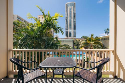 a patio with a table and chairs on a balcony at Waikiki Heritage Hotel in Honolulu
