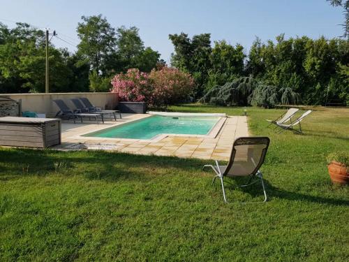 a yard with a swimming pool and a chair at Au Epicéah, logement à la campagne in Valence