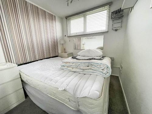 a bedroom with a large bed in a room with a window at Lovely 4 Berth Chalet In The Coastal Village Of Heacham, Ref 92018cs in Heacham