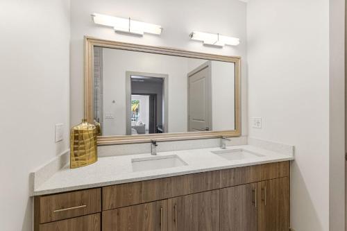 a bathroom with two sinks and a large mirror at the Pointe Unit 125 in Rosemary Beach