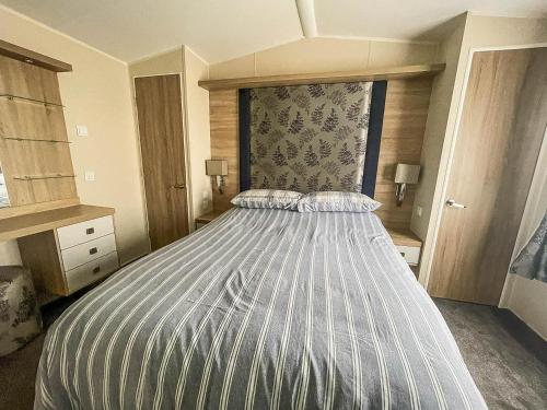 een slaapkamer met een groot bed in een kamer bij 6 Berth Caravan With Wifi At Wells-next-the-sea In Norfolk Ref 72032t in Wells next the Sea