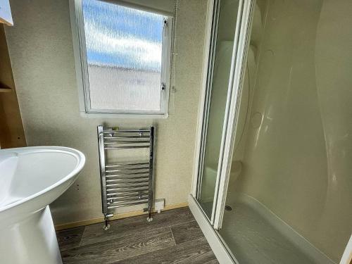 La salle de bains est pourvue d'une douche, de toilettes et d'une fenêtre. dans l'établissement Superb 6 Berth Caravan At Sunnydale Holiday Park Ref 35079a, à Louth