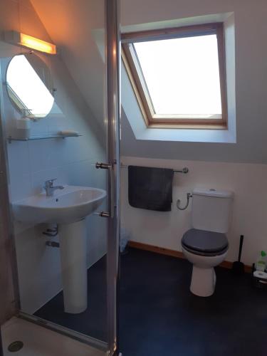 une salle de bain avec toilettes, lavabo et fenêtre dans l'établissement Keranmeriet B near Pont Aven, Concarneau, beaches 15km, à Melgven