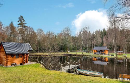 a log cabin on a lake with a boat at Beautiful Home In Bjärnum With Wifi in Bjärnum