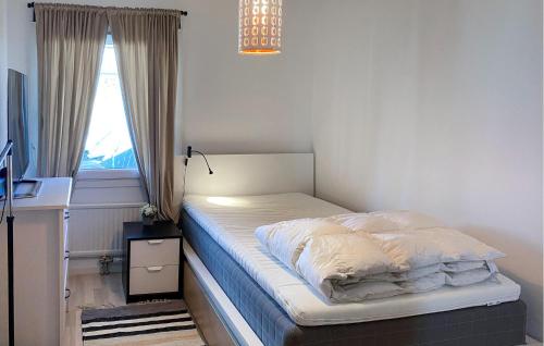 a bed sitting in a bedroom with a window at 2 Bedroom Amazing Apartment In Skrholmen in Stockholm