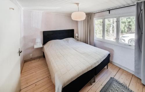 a bedroom with a large bed in a room with windows at Lovely Home In Alingss With Lake View in Alingsås