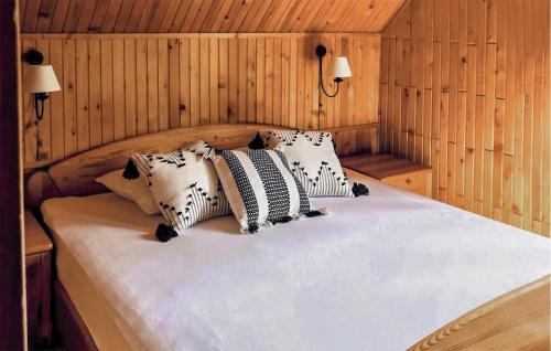 a bed with four pillows on it in a room at 3 Bedroom Beautiful Home In Studzienice in Studzienice
