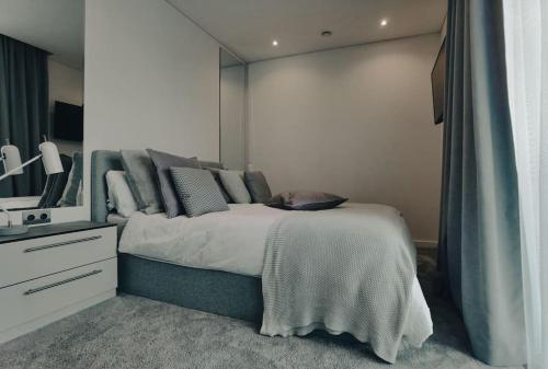 una camera con un grande letto e uno specchio di Brand new apartment in Vilnius center. a Vilnius