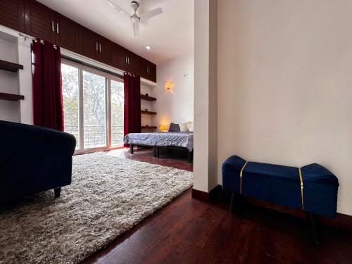 een woonkamer met een bed en een groot raam bij Luminary Dynasty House in Gurgaon