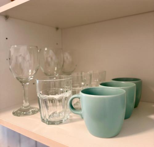 a shelf with cups and wine glasses on it at Wohnung im Zentrum 1 in Magdeburg
