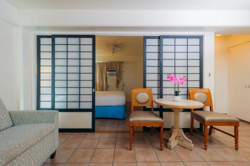 a room with a couch and a table and a bed at Waikiki Heritage Hotel in Honolulu