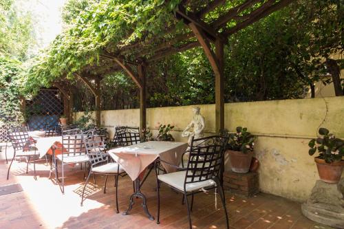 a patio with tables and chairs under a pergola at Hotel Roma in Pisa