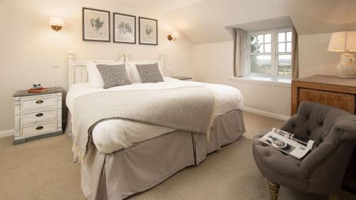 a bedroom with a bed and a chair at The Sheep Cote, Pentland Hills in Nine Mile Burn