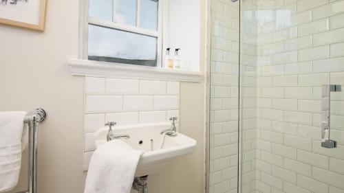 a bathroom with a sink and a glass shower at The Sheep Cote, Pentland Hills in Nine Mile Burn