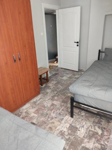 een slaapkamer met een bed en een houten deur bij arya apart in Ayvalık