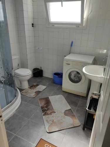 een badkamer met een wasmachine en een wastafel bij arya apart in Ayvalık