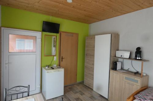 een kamer met groene muren en een witte koelkast bij Radlerzimmer (Zweibettzimmer) in Strasen