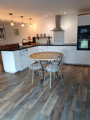 une cuisine avec une table et des chaises dans l'établissement Charmant, à Riscle