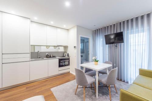 a kitchen and living room with a white table and chairs at Terro Collection - Eça de Queirós in Braga